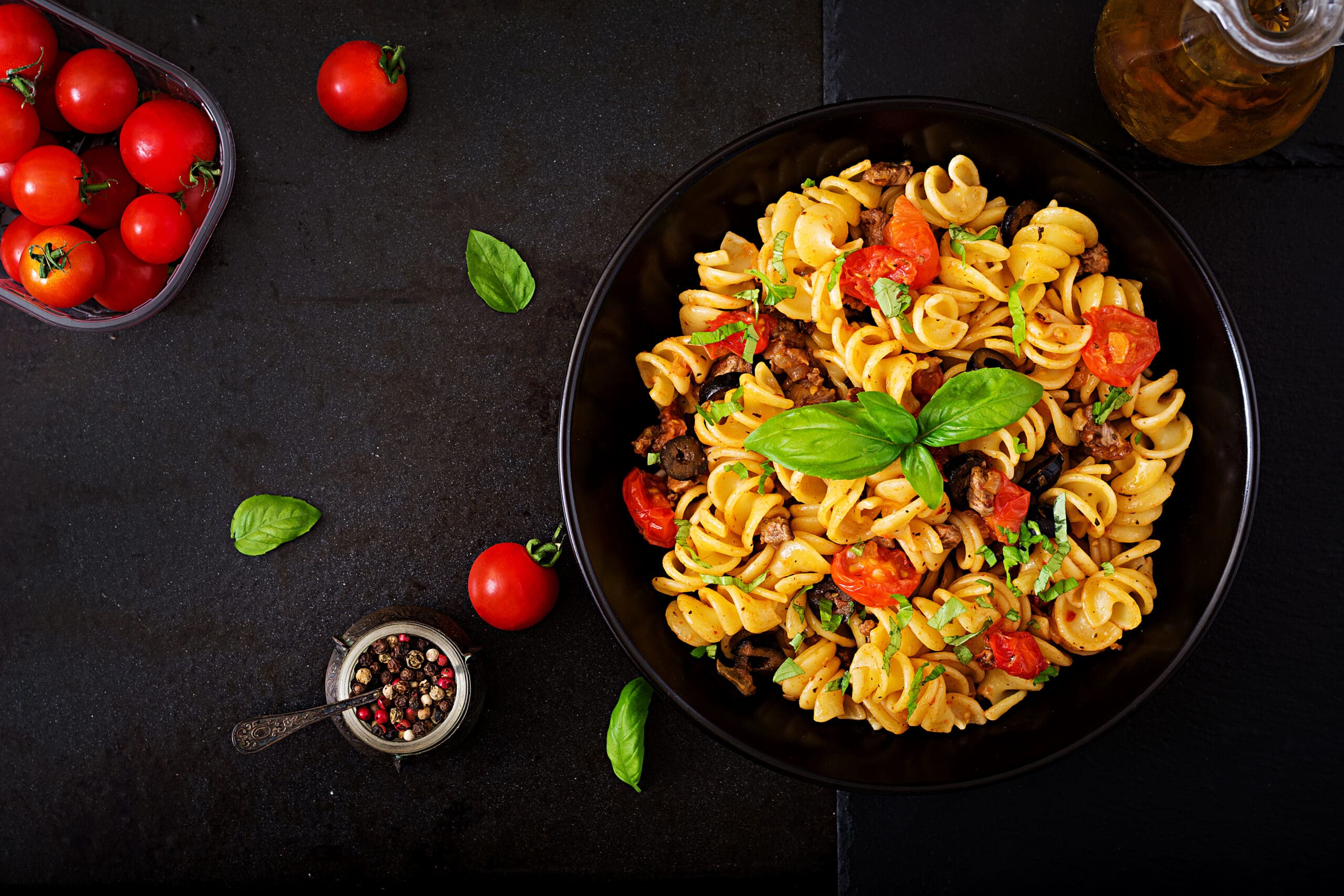 Pasta,Fusilli,With,Tomatoes,,Beef,And,Basil,In,Black,Bowl